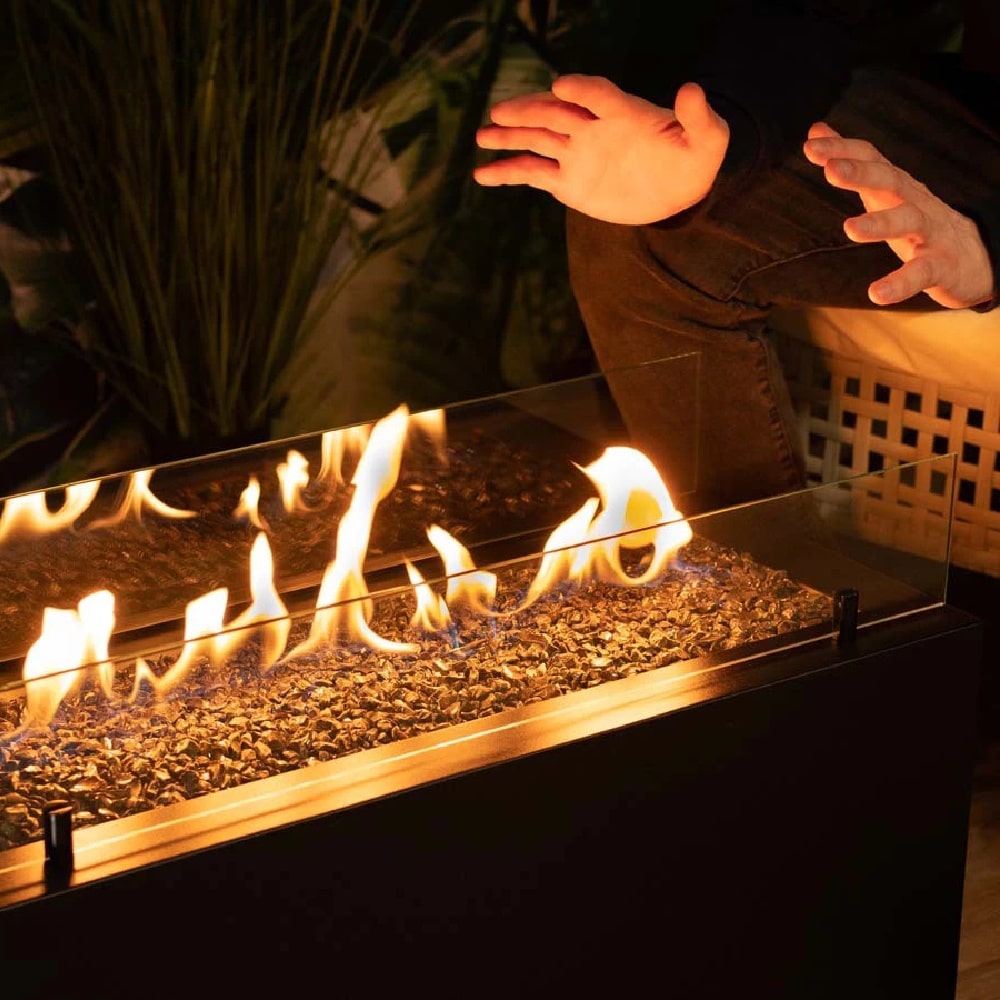 planika rio outdoor fireplace people warming hands view